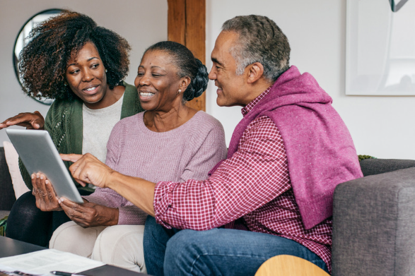 Daughter showing her parents how to use tablet