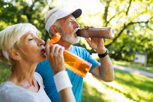 elderly couple drinking water in the park