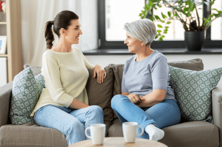 Adult daughter talking to her elderly mother