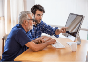 Adult Son showing his elderly father how to use the computer