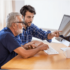 Adult Son showing his elderly father how to use the computer