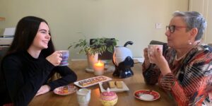 Grandmother and Granddaughter having a cup of tea and biscuits together