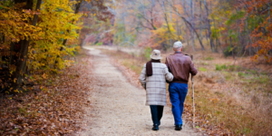 Elderly couple walking a path in the woods