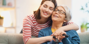 Adult daughter hugging her elderly mother (Photo Cred: Canva)